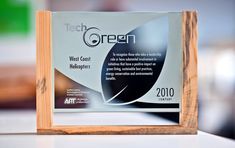 an award plaque sitting on top of a white counter next to a wooden frame with the words tech green