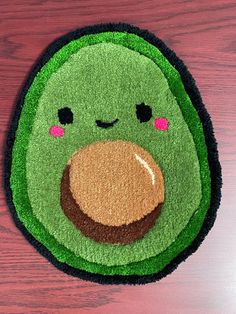 a close up of a rug on a wooden surface with a green object in the middle