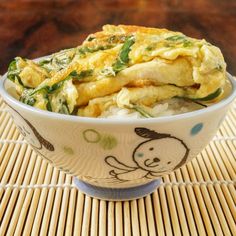 a bowl filled with food sitting on top of a bamboo mat