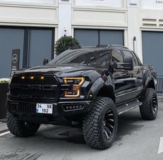 a large black truck parked in front of a building