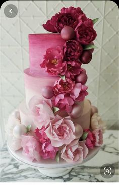 a three tiered cake with pink flowers on top