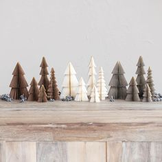 a group of small wooden trees sitting on top of a wooden table next to each other