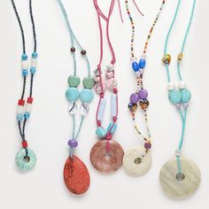 several necklaces with beads and stones on them