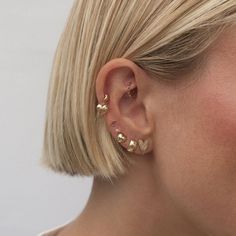 a woman with blonde hair wearing gold ear studs