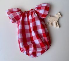 Super pretty red cotton gingham seaside playsuit .  This pretty playsuit has cool sun safe  sleeves . It has snaps at the crotch for easy  nappy changes . It is cool and comfy as well as being stylish.  Perfect matched with some red or gold accessories for the festive season.  Available to order in sizes newborn 0-3 months 3-6 months 6-12,12-18 and 18-24 months . Just select size needed at check out.  Please allow approx 5-7 days for your romper to be handmade.  Thanks for looking.  'Like' Simpl Red Cotton Jumpsuit For Playtime, Plaid Cotton Bubble Romper For Summer, Summer Plaid Cotton Bubble Romper, Summer Cotton Plaid Bubble Romper, Playful Red Jumpsuits And Rompers For Summer, Cute Red Cotton Jumpsuit And Rompers, Cute Red Cotton Jumpsuit/romper, Playful Red Summer Jumpsuit, Red Cotton Holiday Onesie