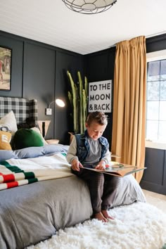 a young boy sitting on top of a bed