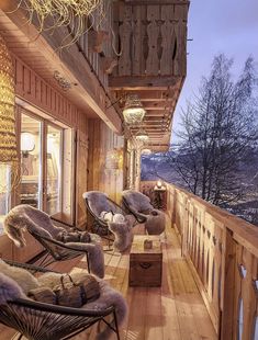 an outdoor deck with chairs and lamps on the top floor, looking out onto mountains