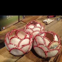 three baseballs sitting on top of a wooden table