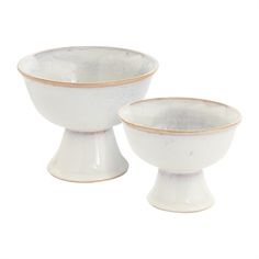 two white bowls with gold rims sitting on top of each other in front of a white background