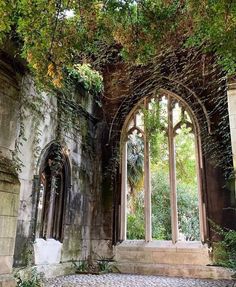 an old building with ivy growing on it's walls and two large arched windows