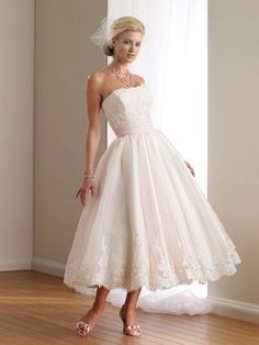 a woman in a white dress standing on a wooden floor