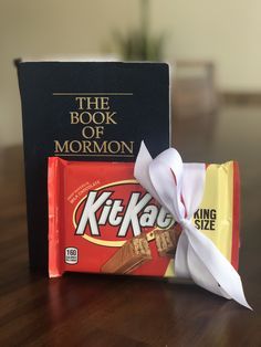 the book of mormon and kitkato are sitting next to each other on a table