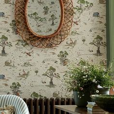 a mirror hanging on the wall next to a chair and table with flowers in it