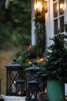 christmas trees and lanterns are on the porch