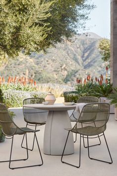 an outdoor table with four chairs around it