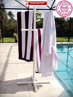 two towels are hanging on a rack next to a pool