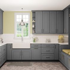 a large kitchen with gray cabinets and white counter tops is shown in this image, there are two windows above the sink