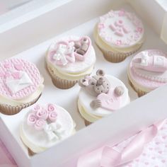 cupcakes decorated with pink and white icing in a box