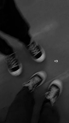 black and white photograph of two people standing next to each other with their feet on the ground