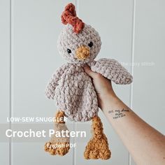 a hand holding a crochet chicken toy in front of a white background with the words slow sew smugle crochet pattern on it