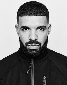 a black and white photo of a man with a beard wearing a jacket, looking at the camera