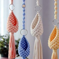 several tasseled beads hanging from hooks in various colors and sizes on a table