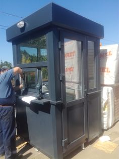 a man standing next to a large black box