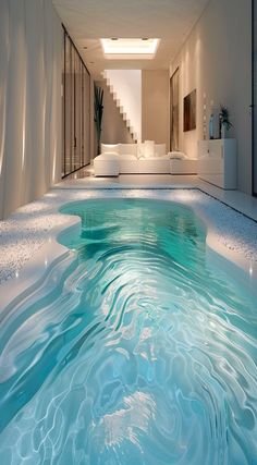 an indoor swimming pool in the middle of a room with stairs leading up to it