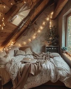 a bedroom with lights strung from the ceiling and a laptop on the bed in front of it