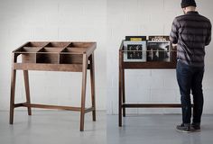 a man standing in front of a desk with a magazine rack on top of it