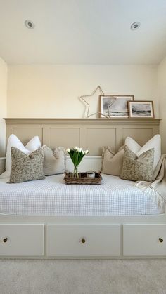 a white bed with lots of pillows on top of it