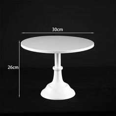 a white table with measurements for the top and base, in front of a black background