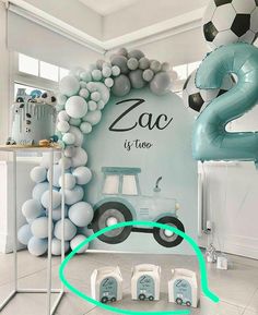 a room decorated with balloons, soccer balls and a car on the wall that says zac it's too