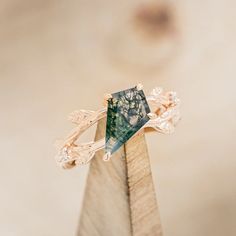 a close up of a ring on top of a piece of wood