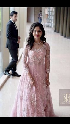 a woman in a pink gown standing next to a man