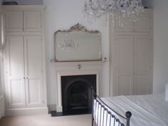 a bedroom with a bed, dressers and a chandelier