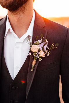 a man in a suit with a boutonniere and flowers on his lapel