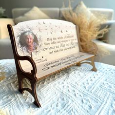 a wooden bench with a memorial plaque on it sitting on a table in front of a couch