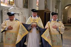 three men in priest robes standing next to each other