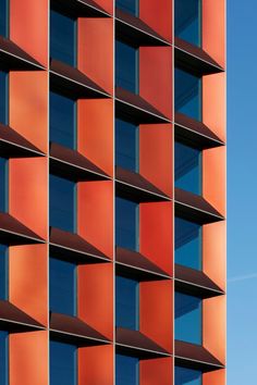 the side of an orange building with lots of windows