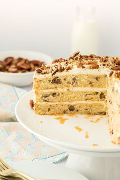 there is a piece of cake that has been cut from it and sits on a plate