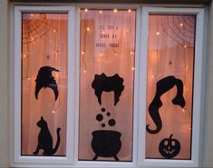 three windows with halloween decorations on them