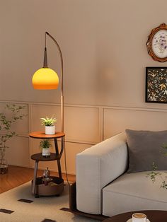 a living room with a couch, table and clock on the wall next to it