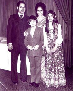 an old black and white photo of a family posing for a picture in front of a curtain