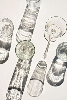 four empty wine glasses sitting next to each other on top of a white countertop