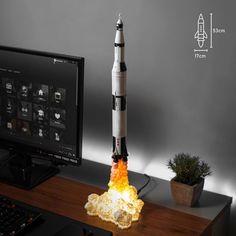 a model rocket sitting on top of a desk next to a computer