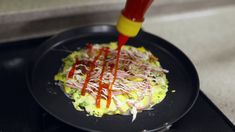 someone is using a hot glue stick to paint the food on top of the plate