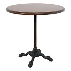 a wooden table with metal legs and an ornate design on the top, against a white background