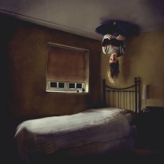 a person upside down on a bed in a room