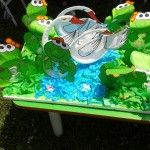 this is a cake made to look like the frog driving a car with other cars on it